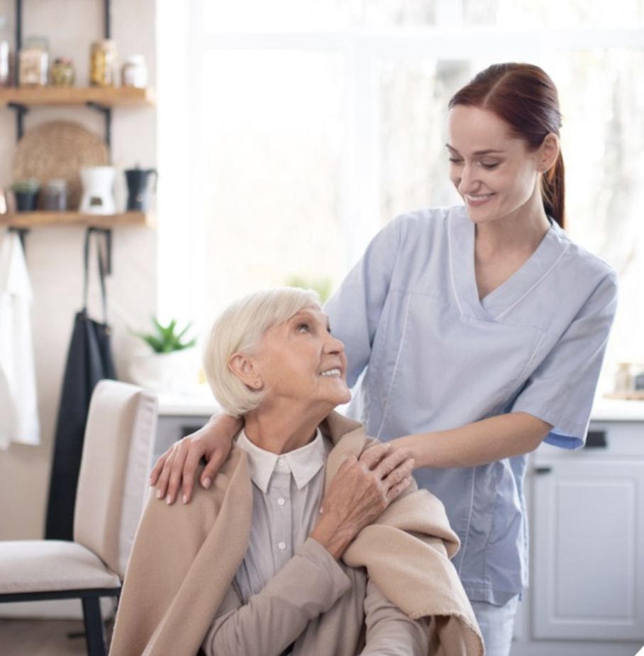 Caregiver and elderly woman engaging in a fun activity, surrounded by art supplies and a cheerful atmosphere in Huntersville, NC